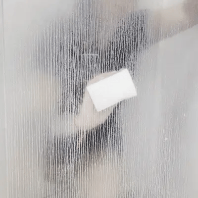 Toalha branca limpando vidro embaçado com gotas de água