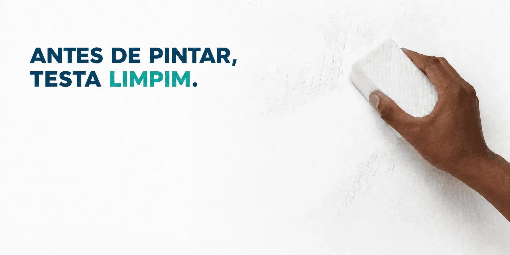 Mão limpando parede branca com pano, antes de pintar, teste Limpim.